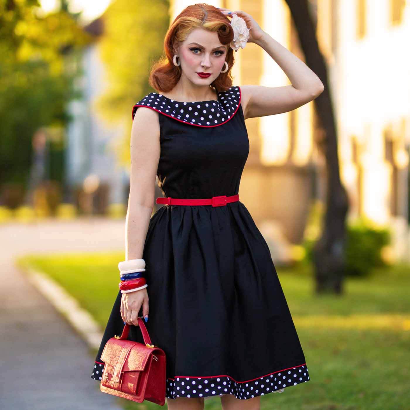Dolly and Dotty Cindy 50s Dress - Black model in a park with mathcing red bag. 