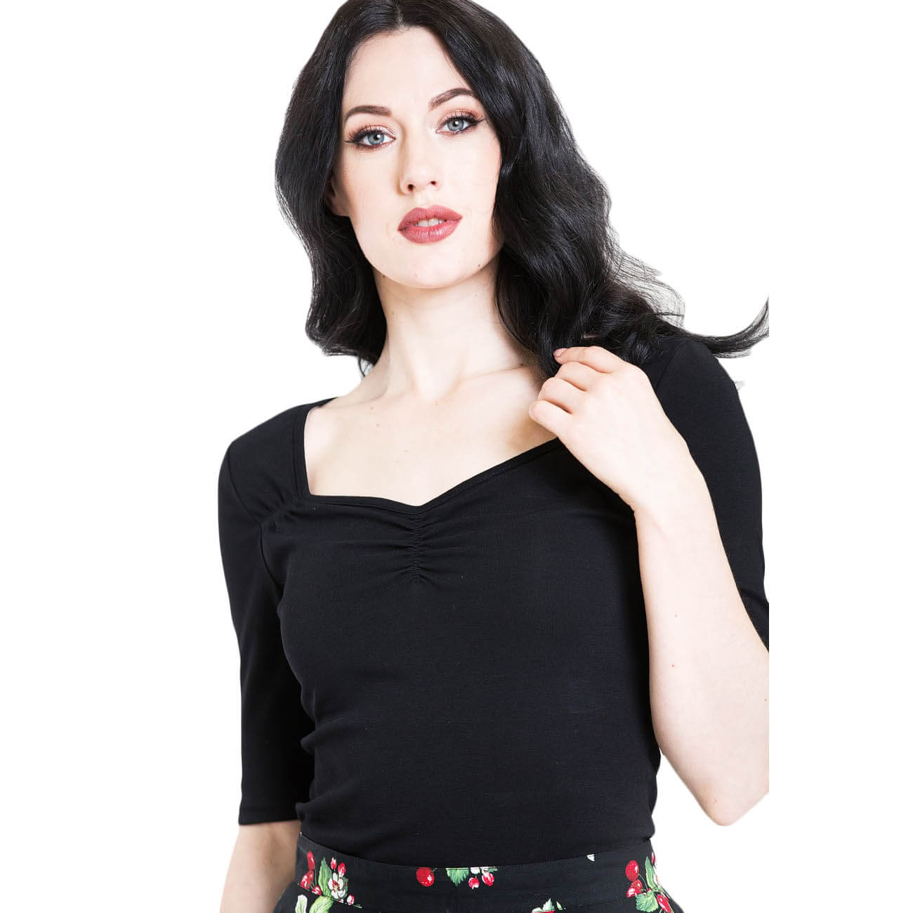 A model with black hair looking straight ahead is wearing hell Bunny black retro style philippa blouse